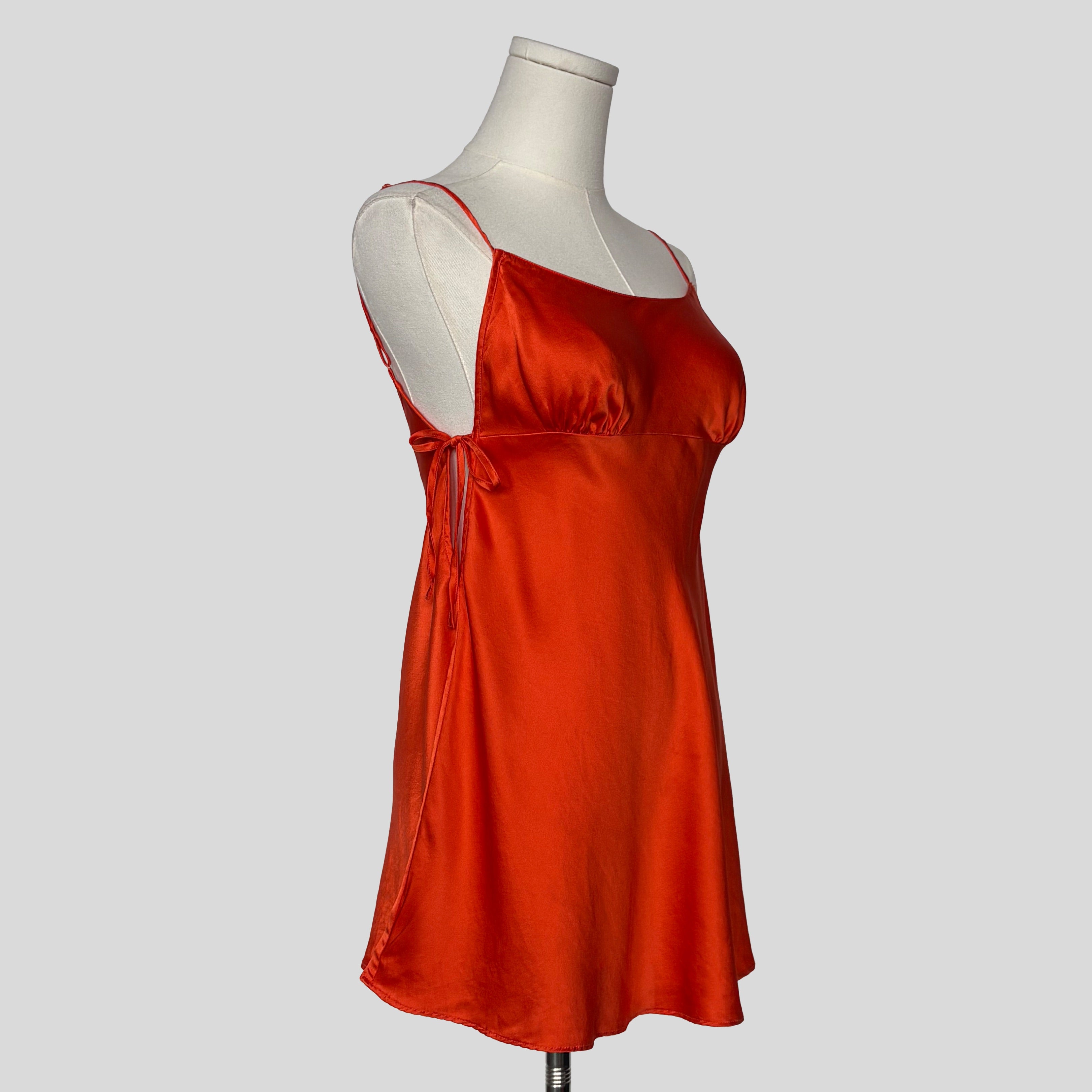 Silk slip dress with side cutouts and bows in orange