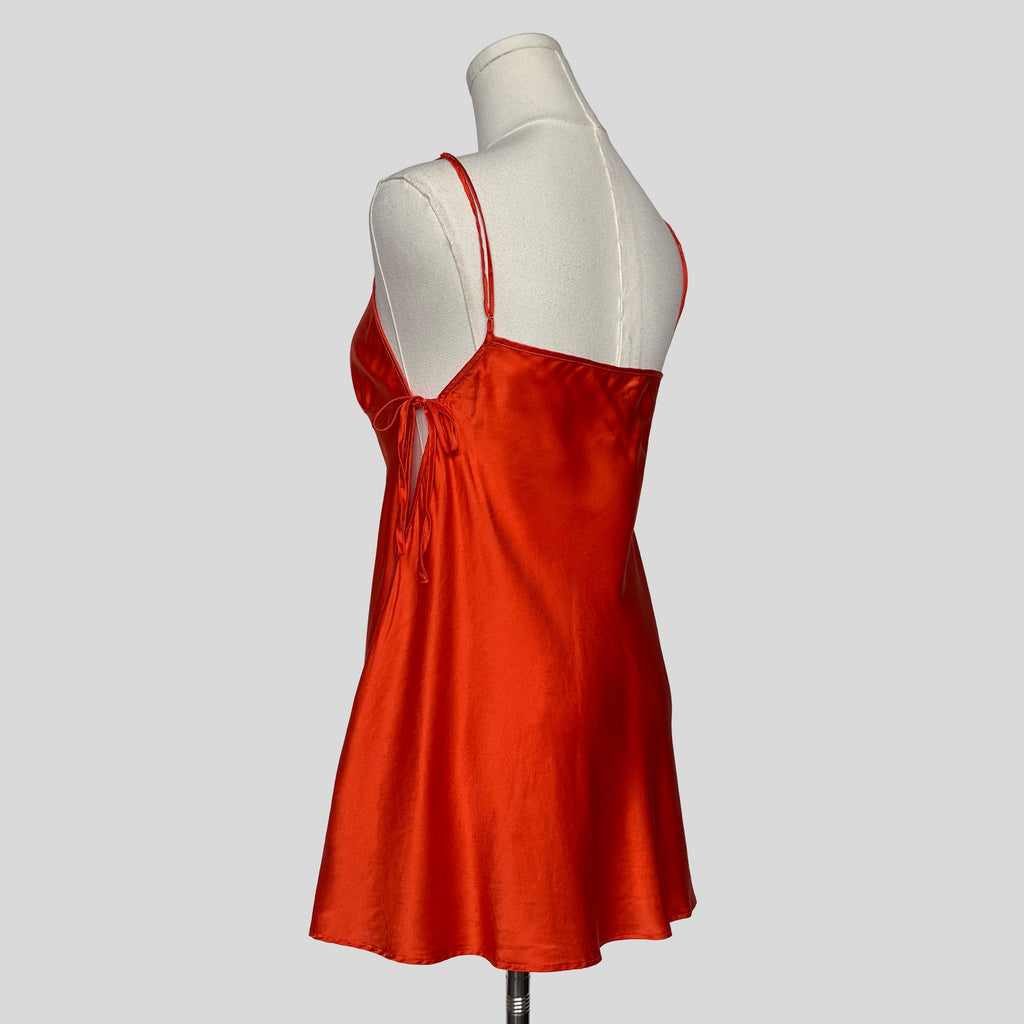 Silk slip dress with side cutouts and bows in orange