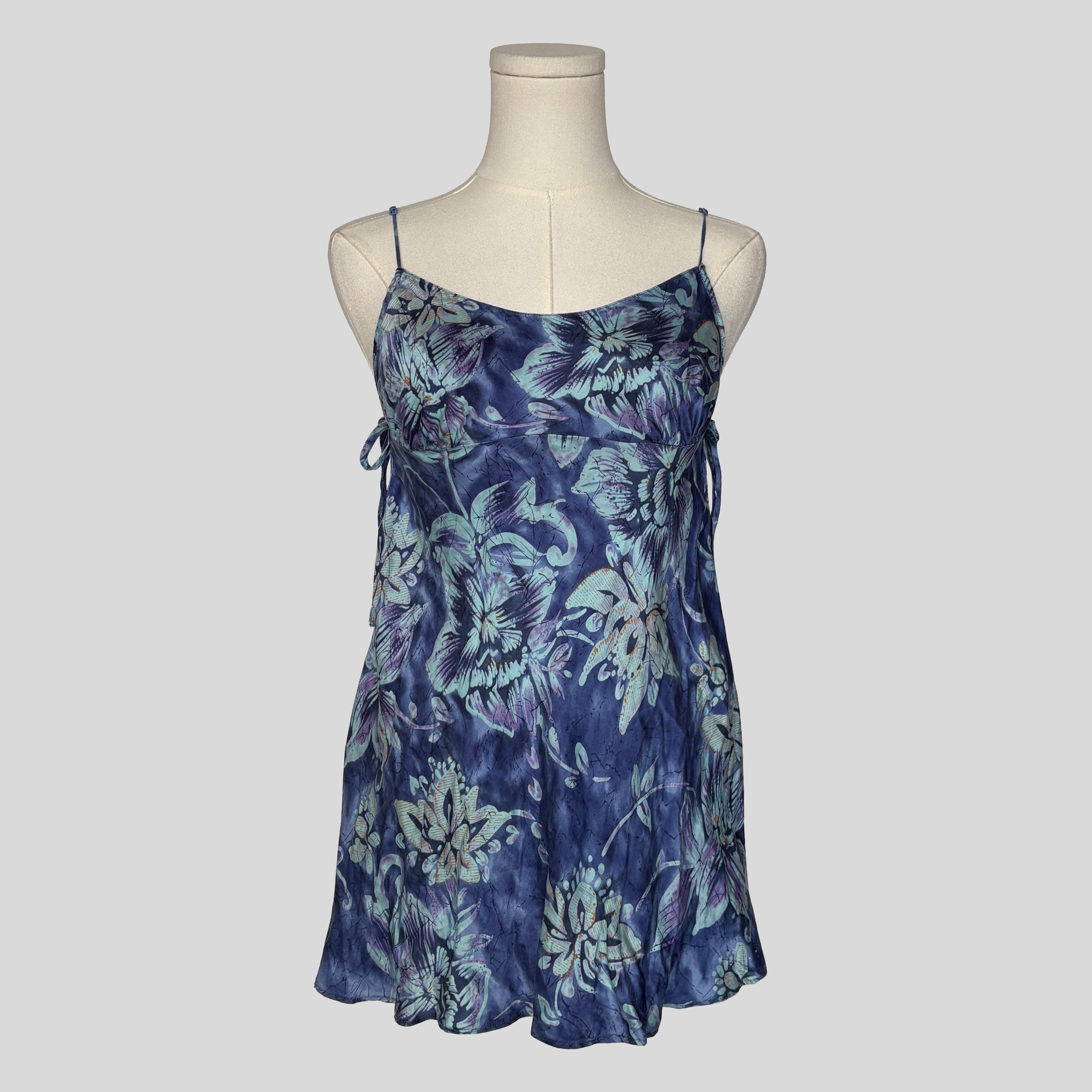 Silk slip dress with side cutouts and bows in blue floral